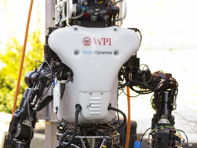 Atlas holding a cordless drill during the wall task