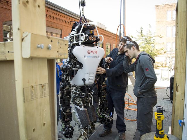 Team members adjusting Atlas at the door